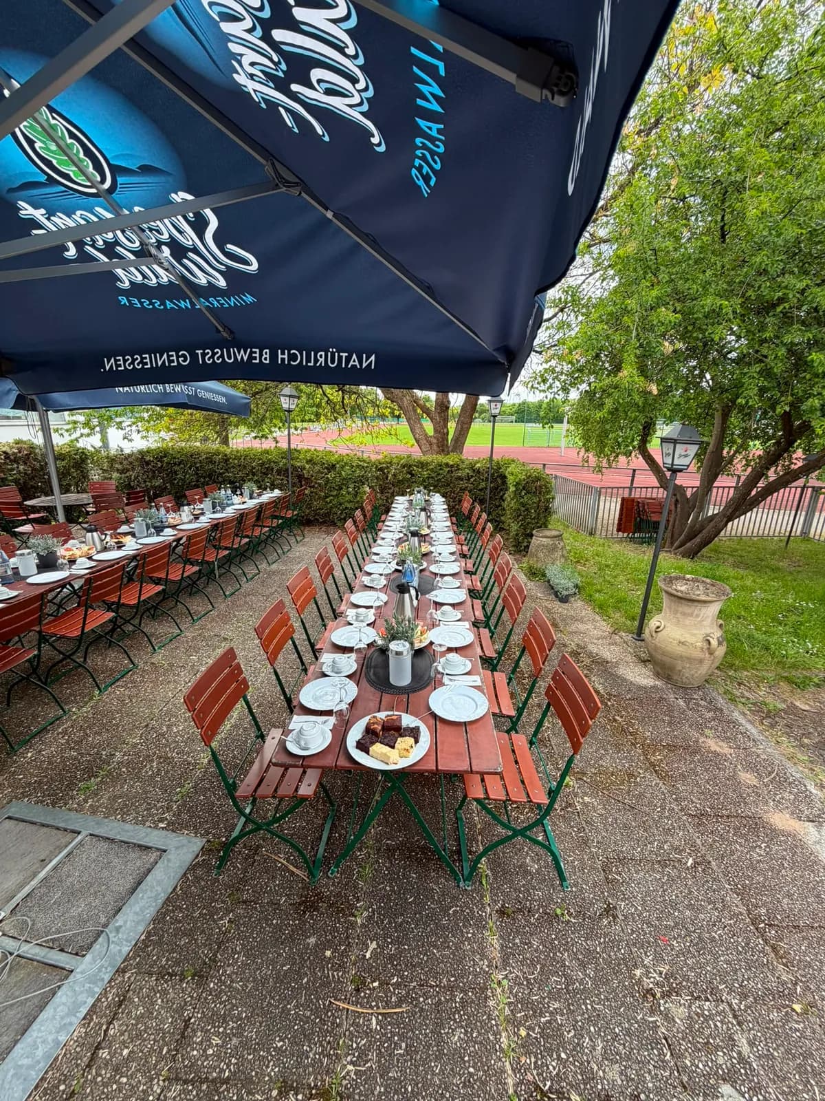 Eingedeckte Tische im Biergarten, bereit für die Gäste.